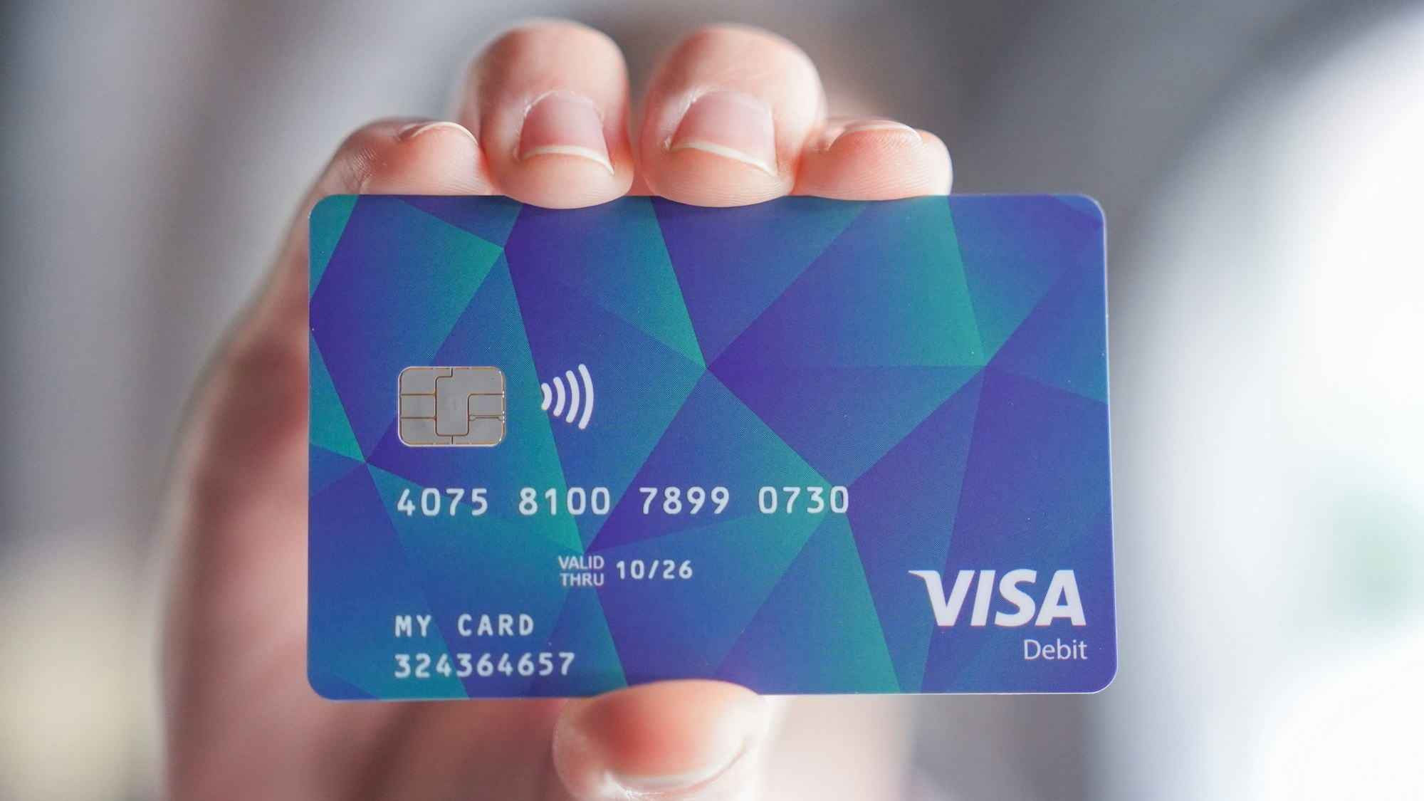 Ein Mann hält eine Hamburger Bezahlkarte für Asylsuchende in der Hand.