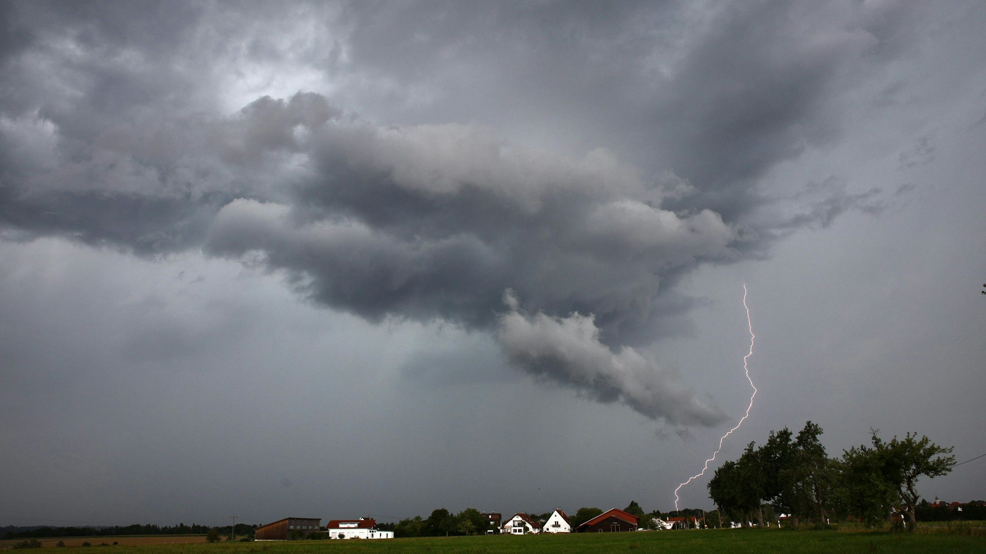 Eine Gewitterzelle liegt über weitem Land.