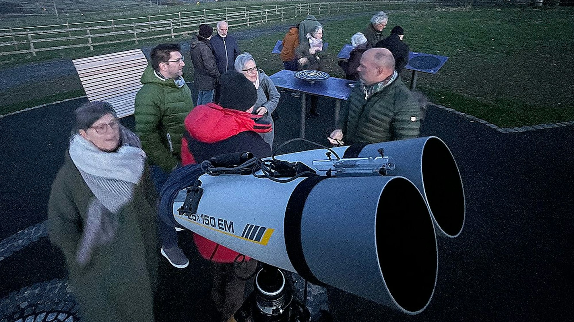 Einige Menschen stehen an einem professionellen Teleskop.