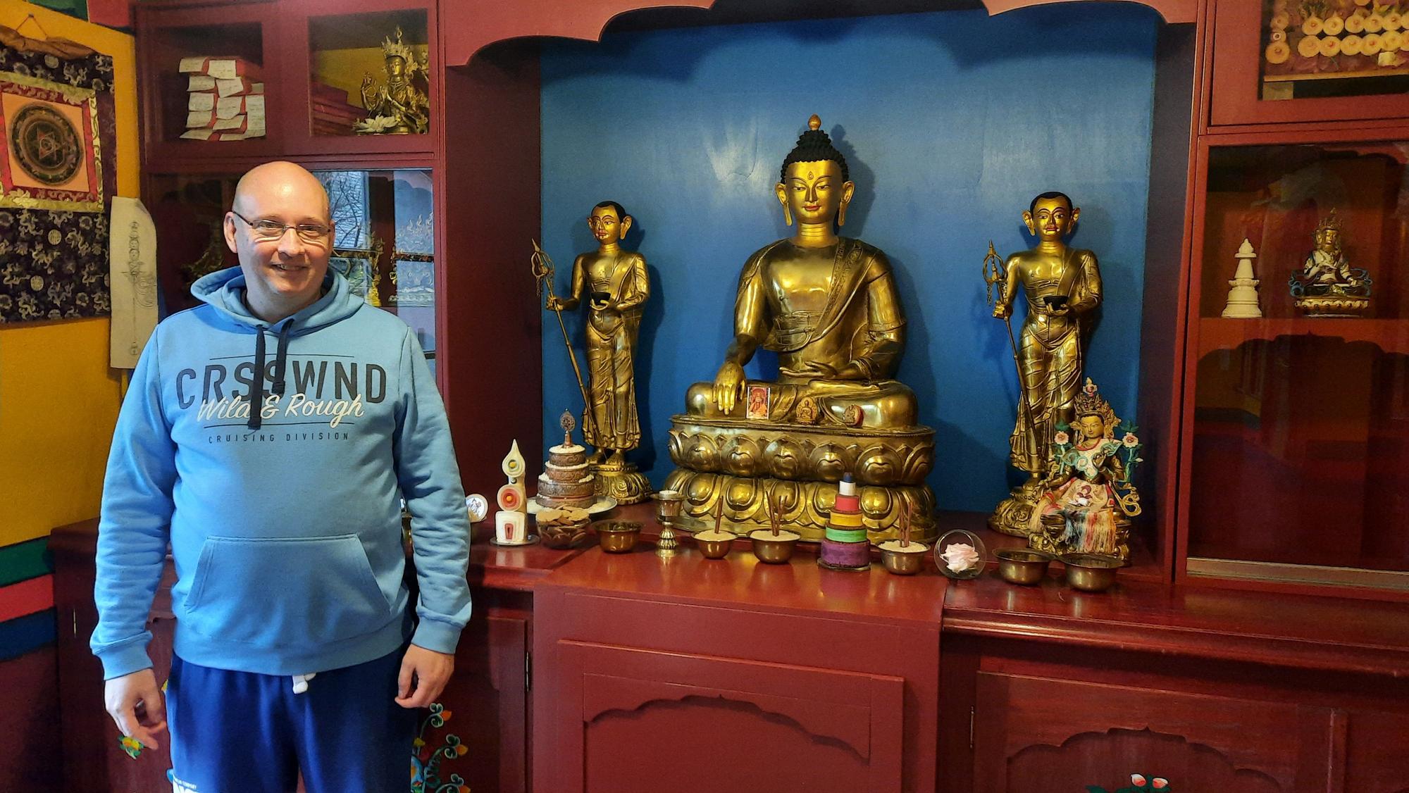 Ein Mann steht vor buddhistischen Statuen