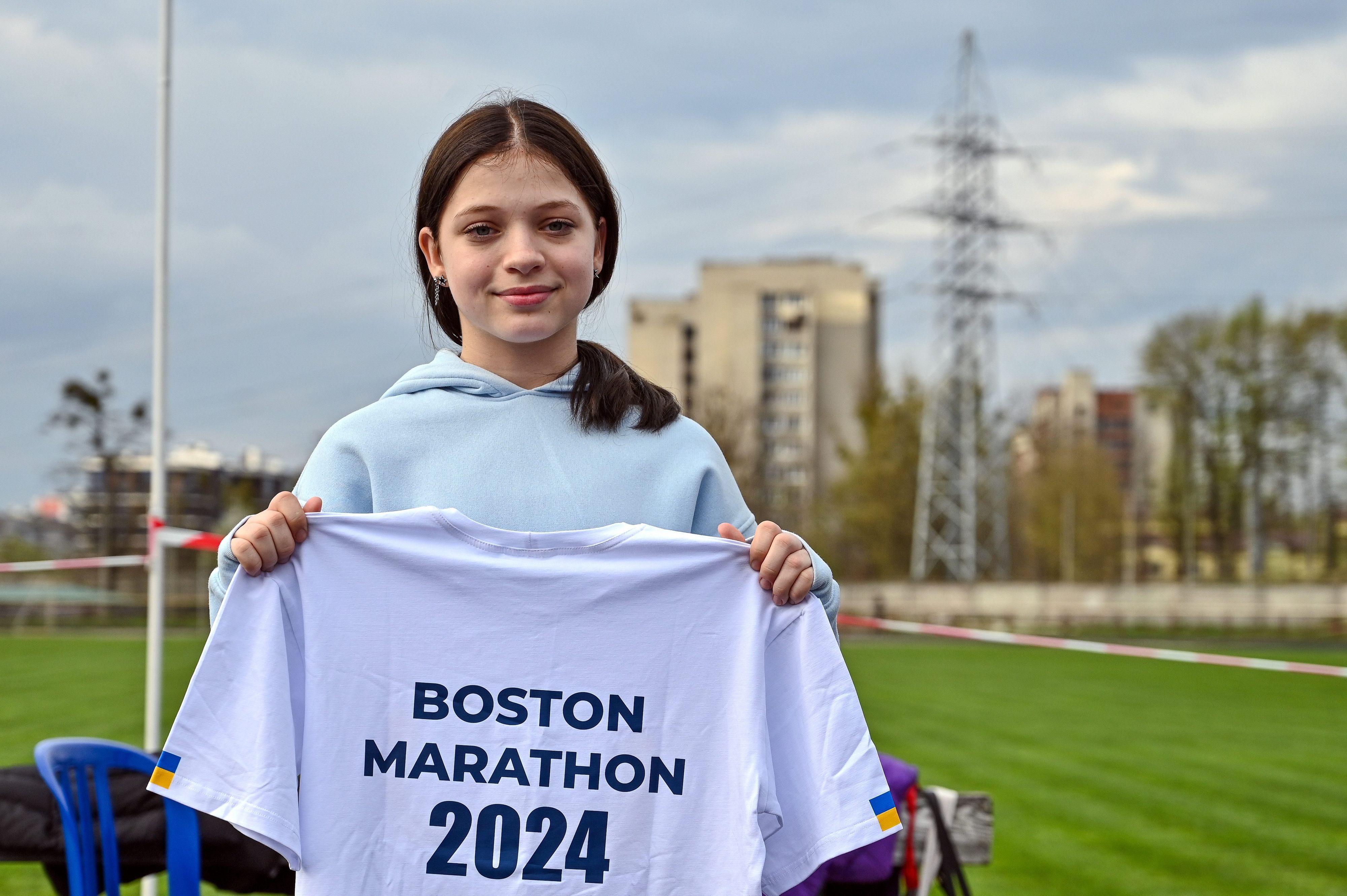Ukraine, Lwiw: Die 12-jährige Ukrainerin Jana Stepanenko zeigt ein T-Shirt mit der Aufschrift „Boston Marathon 2024“.