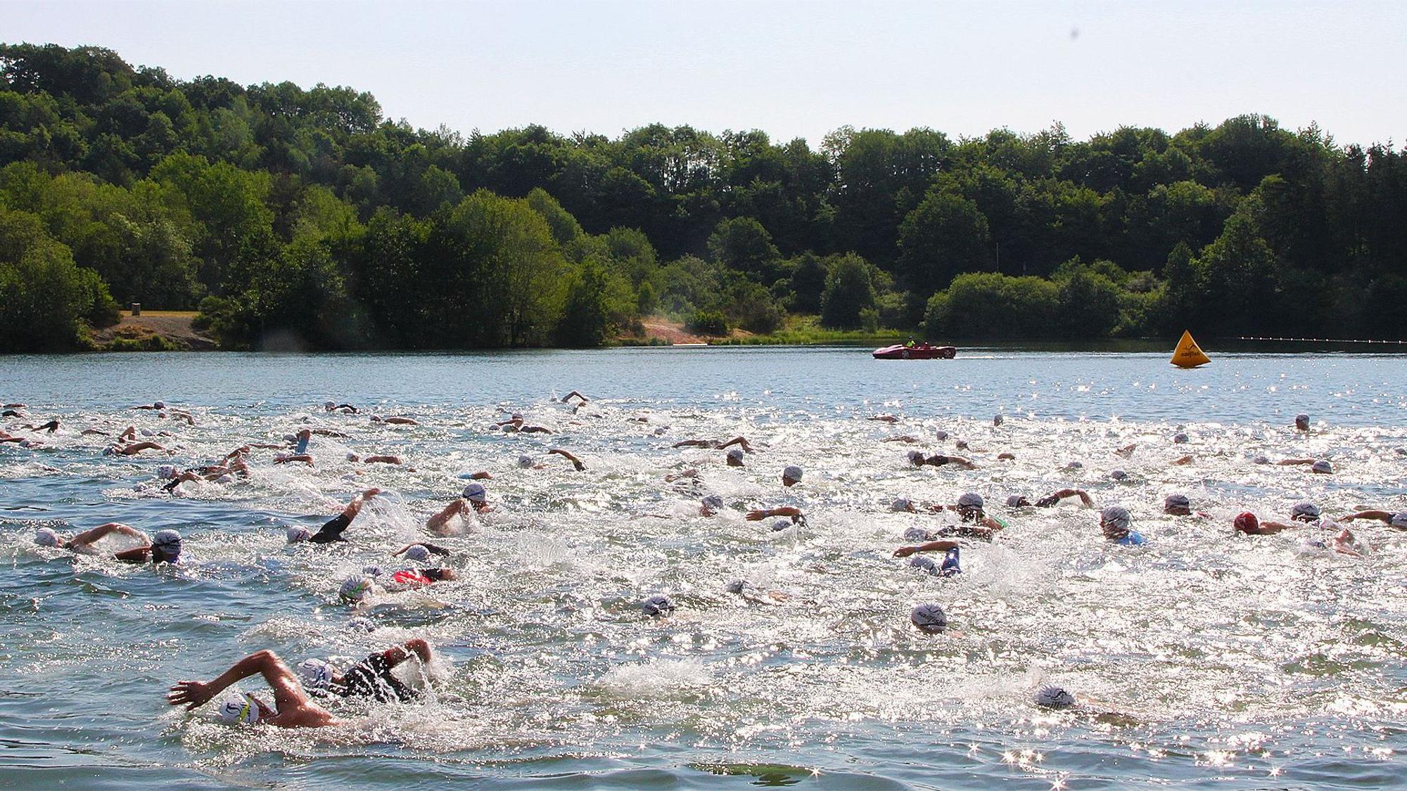 Viele Leute schwimmen durch einen See.