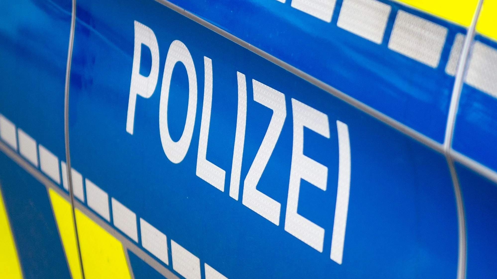 Das Symbolfoto zeigt die Tür eines Einsatzfahrzeugs mit der Aufschrift „Polizei“.