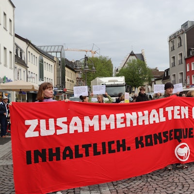 Zu sehen sind die Demonstranten, die ein Banner halten.
