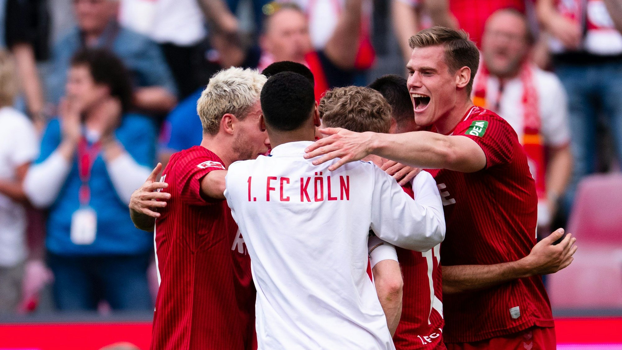 Die Kölner Spieler um Luca Waldschmidt (l) und Steffen Tigges (r) jubeln nach der Partie.