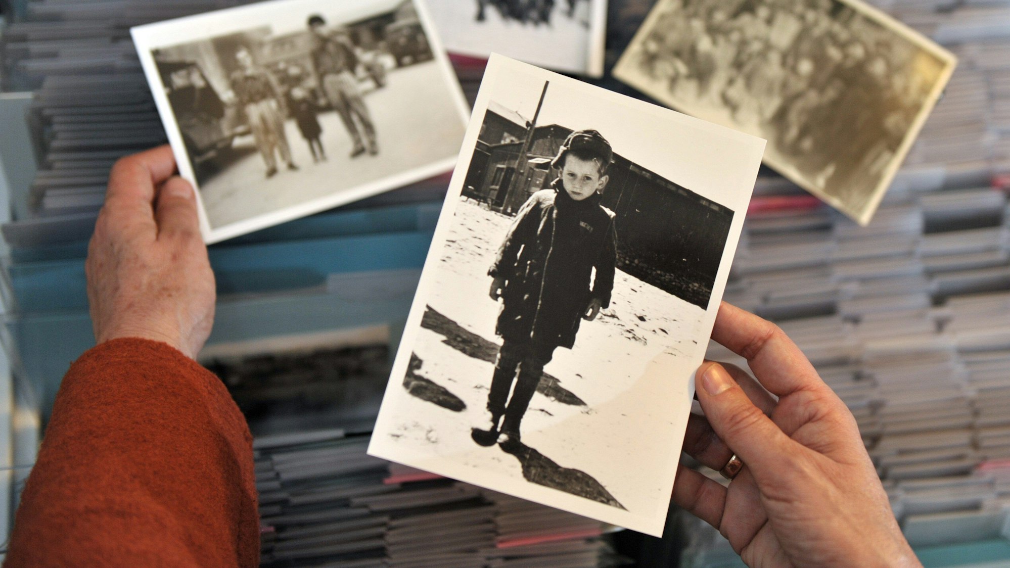 ARCHIV - 29.03.2010, Thüringen, Weimar: Im Archiv der Gedenkstätte Buchenwald bei Weimar betrachtet die Historikerin Sabine Stein eine Aufnahme, die Stefan Jerzy Zweig im April 1945 nach der Befreiung der Kinder im Konzentrationslager Buchenwald zeigt, aufgenommen am 30.03.2010 in Weimar. (zu dpa: ««Buchenwaldkind» Stefan Jerzy Zweig mit 83 Jahren gestorben») Foto: Martin Schutt/dpa +++ dpa-Bildfunk +++