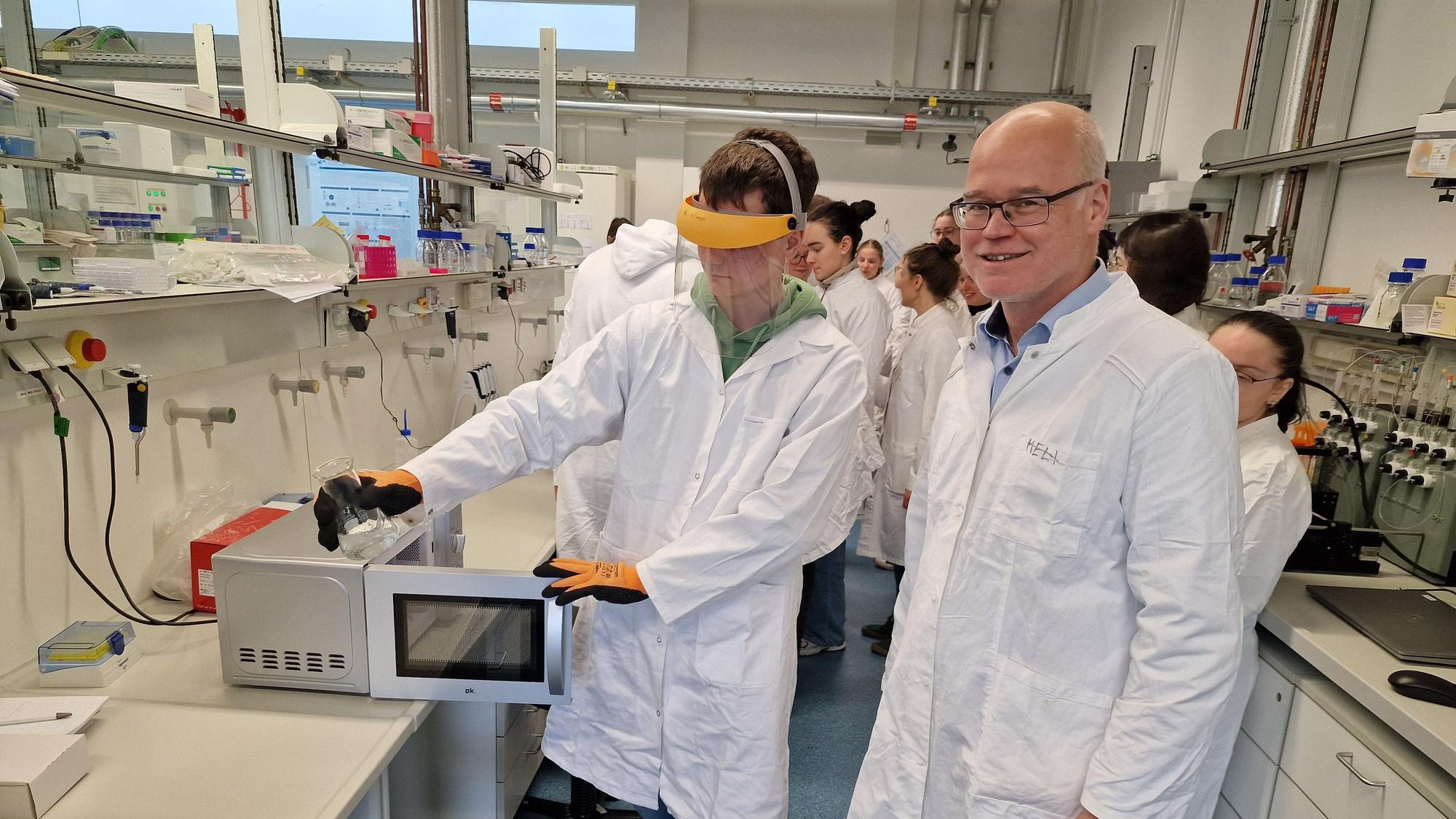 Professor Dr. Christopher Volk (r.) achtet auf richtige Handhabung der Materialien bei der Arbeit im Labor