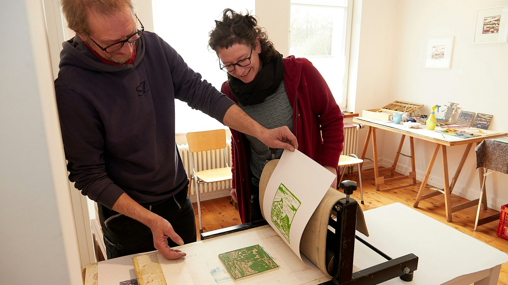 Anne Einer und Thomas Peter schauen sich den Druck an, der frisch aus der Presse kommt.