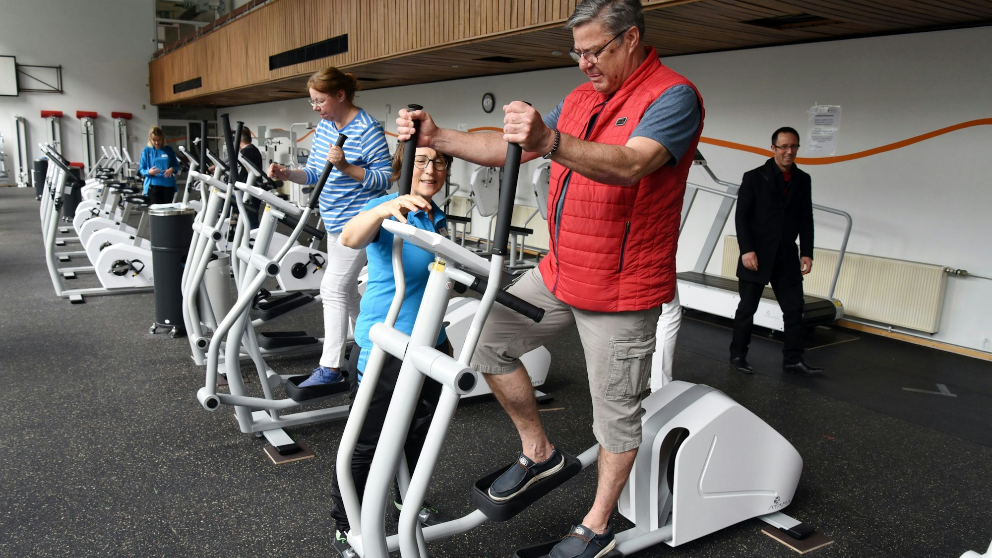 Ein Mann testet unter Anleitung ein Fitnessgerät.