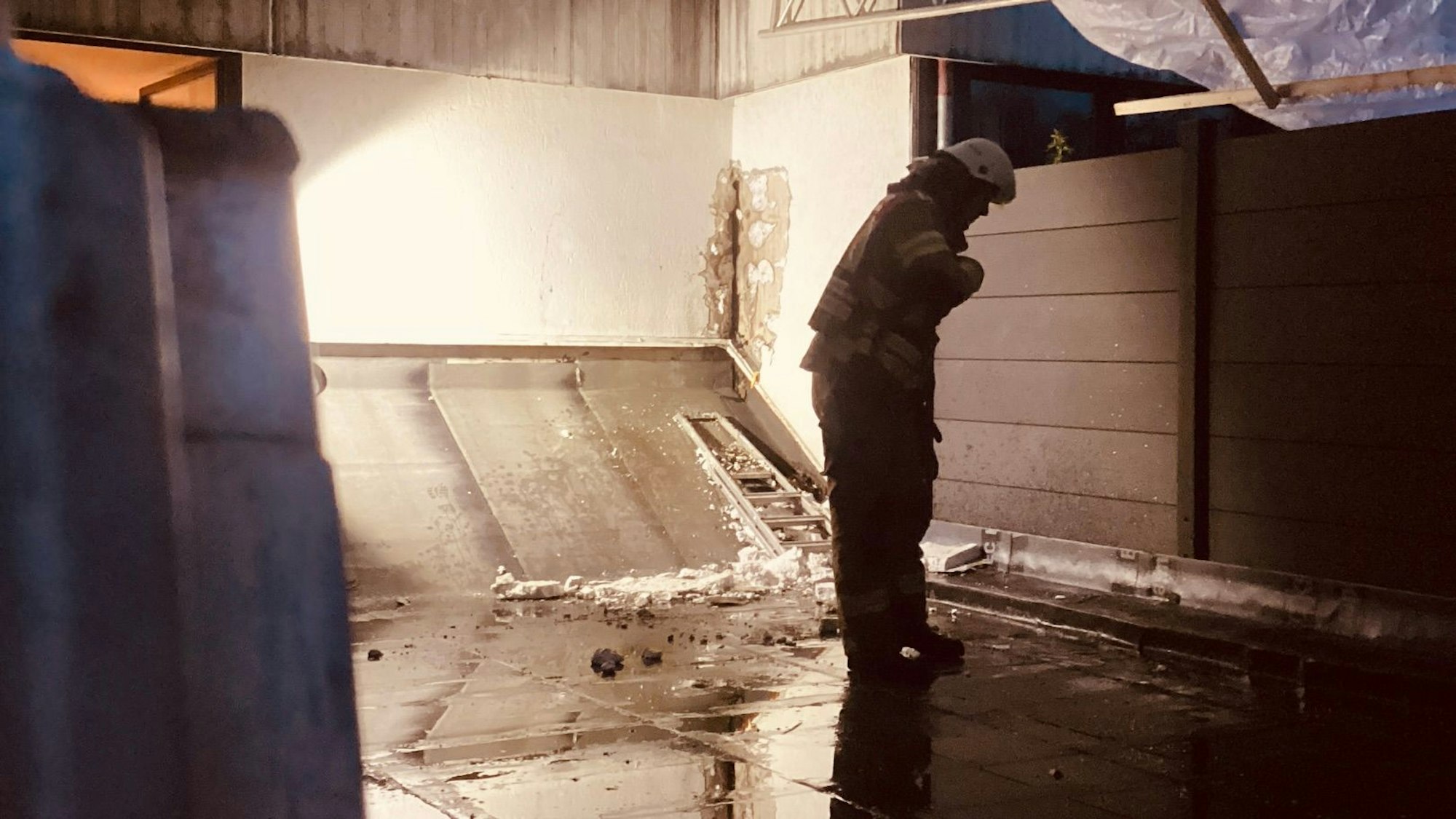 Ein Feuerwehrmann betrachtet im Dunkeln eine Einsatzstelle.