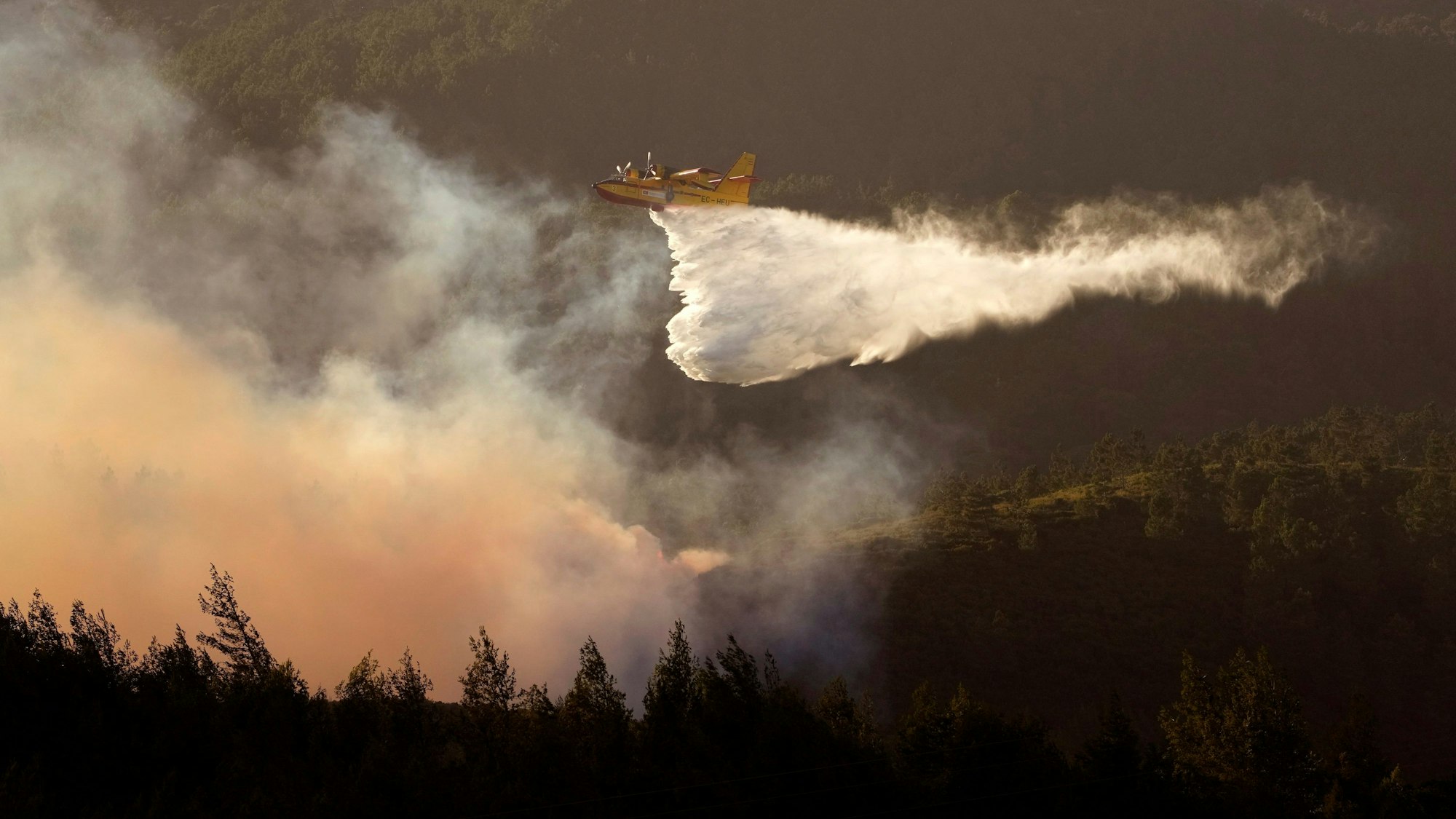 ARCHIV - 25.07.2023, Portugal, Alcabideche: Ein Wasserflugzeug versucht einen Waldbrand in Alcabideche, außerhalb von Lissabon, zu löschen.