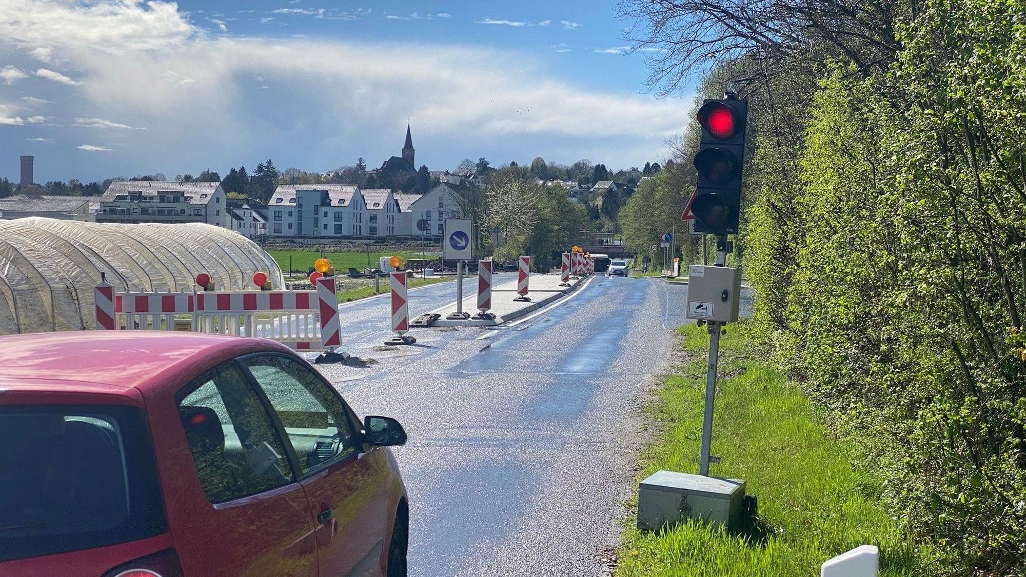 Zu sehen ist ein Auto, das vor der Bedarfsampel steht und dessen Fahrer auf Grünlicht wartet.