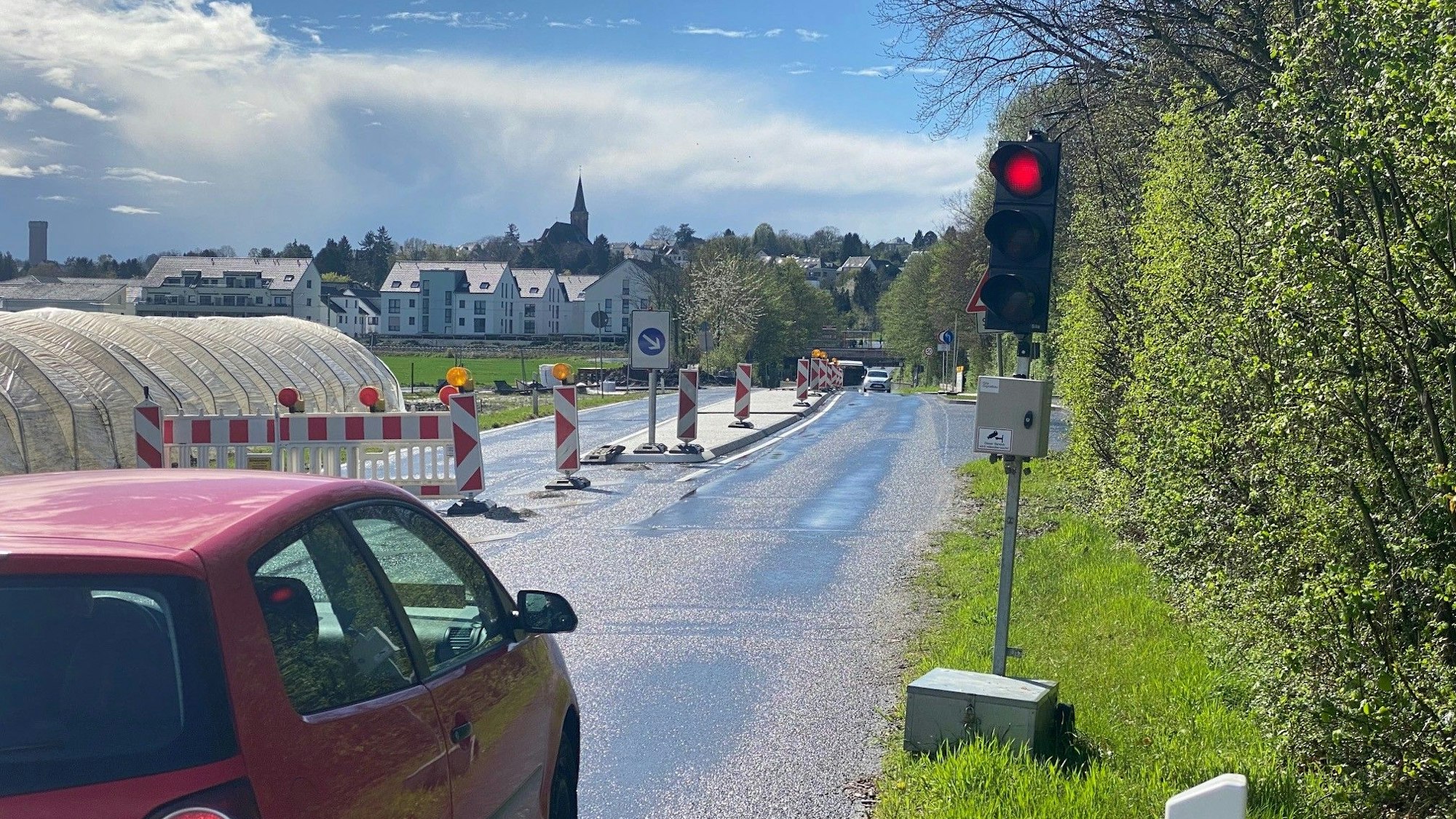 Zu sehen ist ein Auto, das vor der Bedarfsampel steht und dessen Fahrer auf Grünlicht wartet.