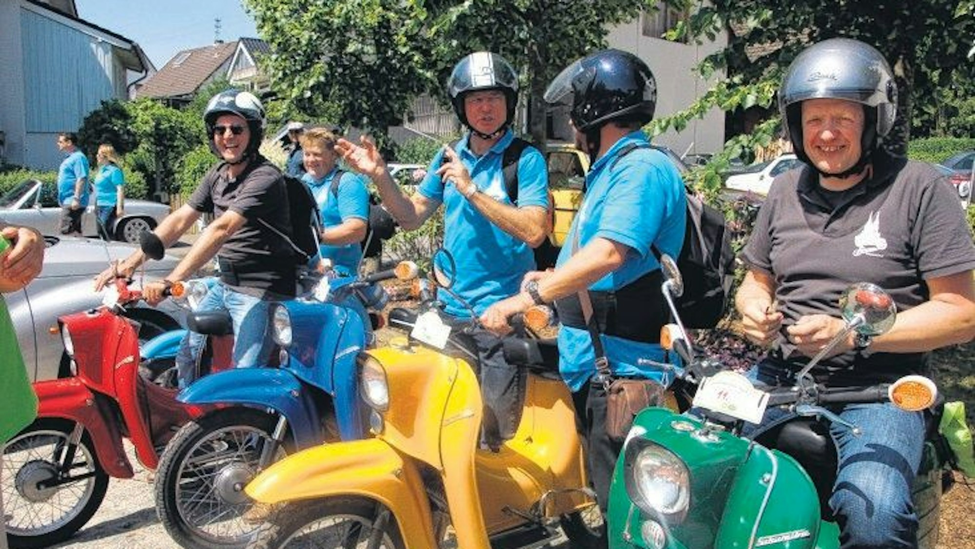 Vier Männer sitzen auf ihren Mopeds.