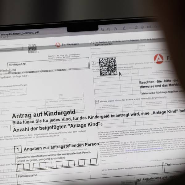 Ein Mensch sitzt vor einem Kindergeld-Antrag an einem Computer.