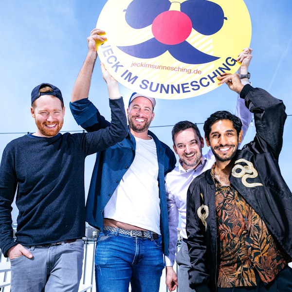 Miljö-Sänger Nils Schreiber (v.l.), Sharkys Geschäftsführer Martin Becker, Björn Lindert von x4kids und Planschemalöör-Frontmann Juri Rother halten ein Jeck im Sunnesching-Schild.