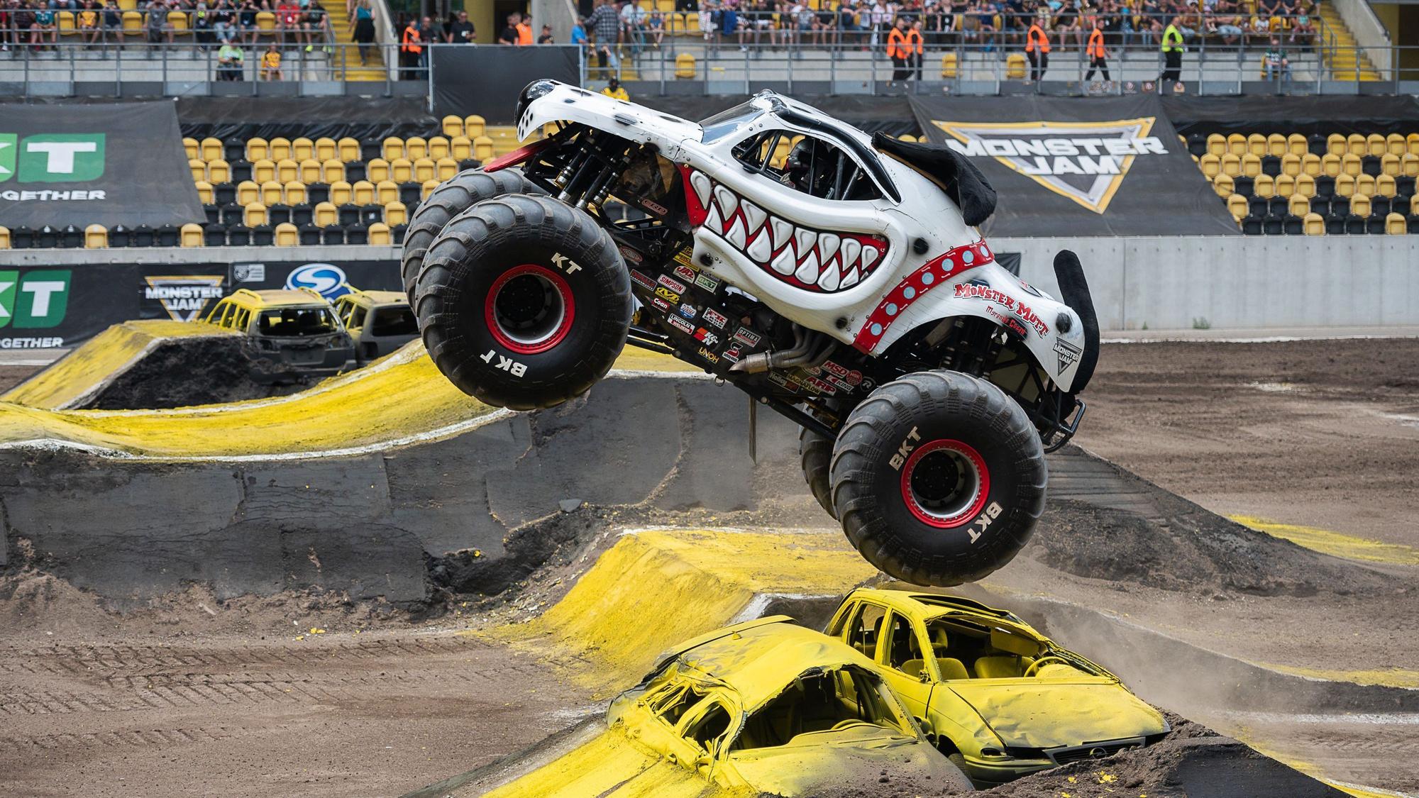 Ein Monstertruck springt über eine Rampe bei einer Show.