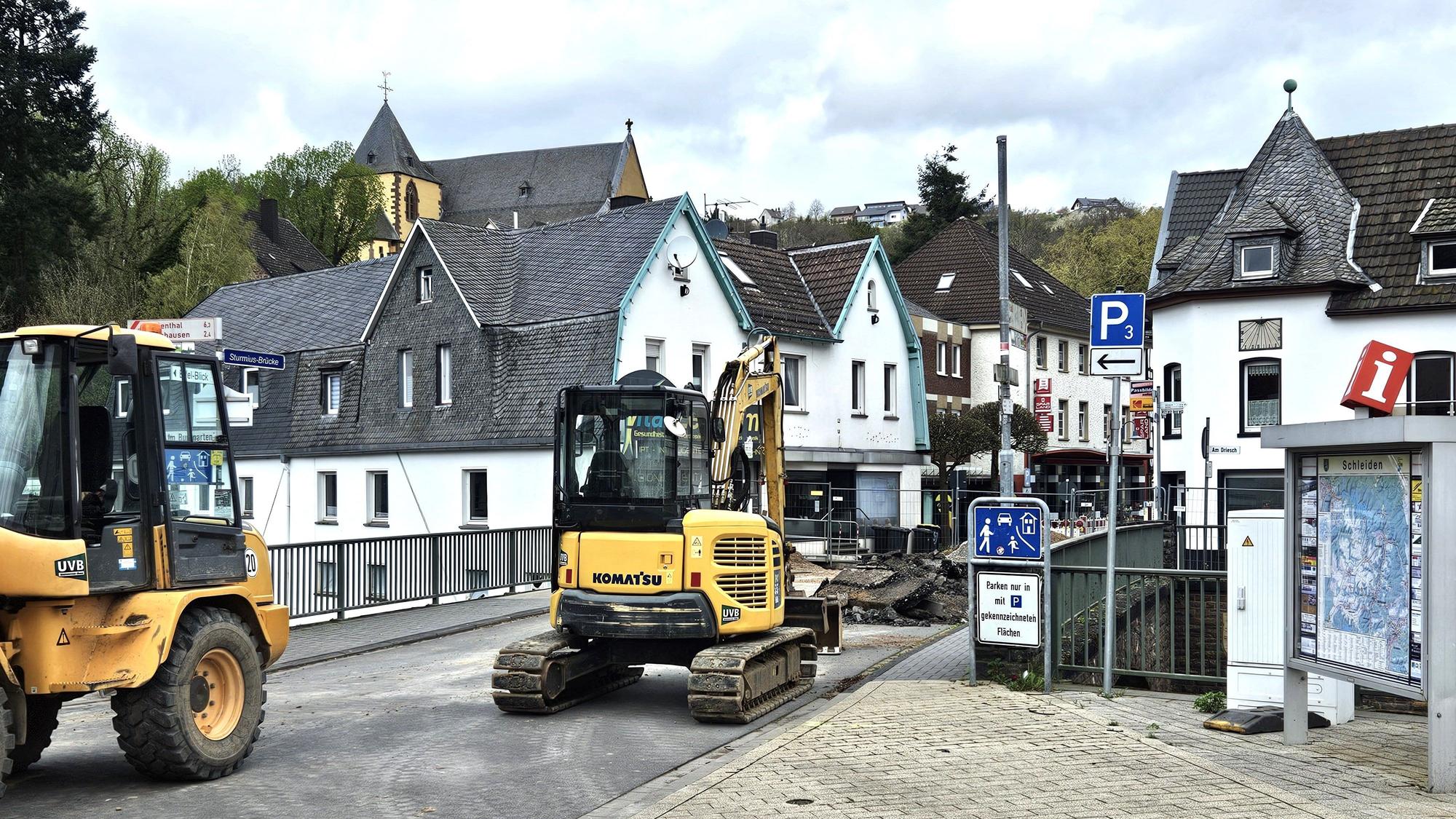 Ein Bagger und ein weiteres Baufahrzeug stehen an der Brücke in der Schleidener Innenstadt.