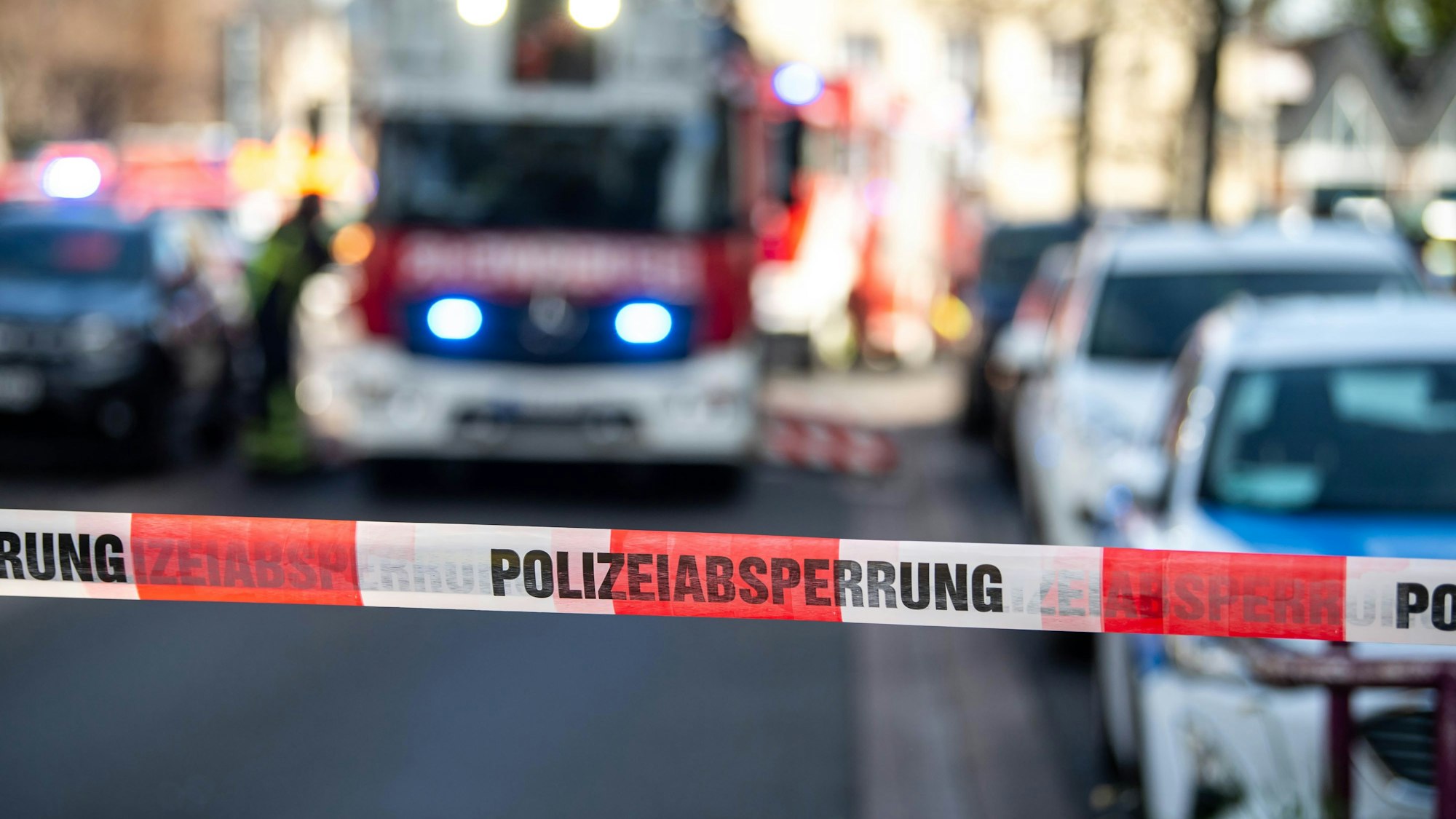 Das Bild zeigt eine Polizeiabsperrung. Im Hintergrund ist ein Feuerwehrfahrzeug zu sehen.