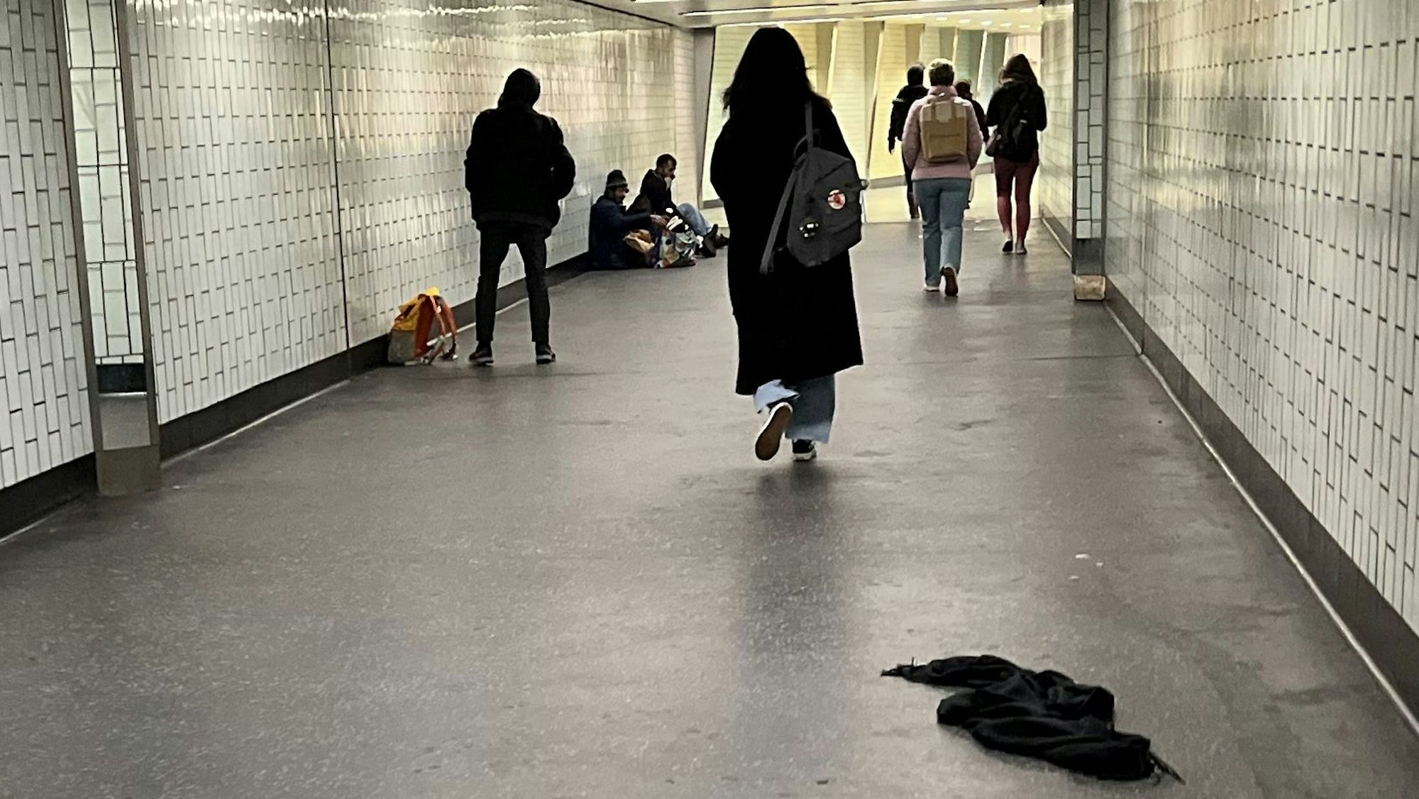 Leute gehen durch einen langen Tunnel