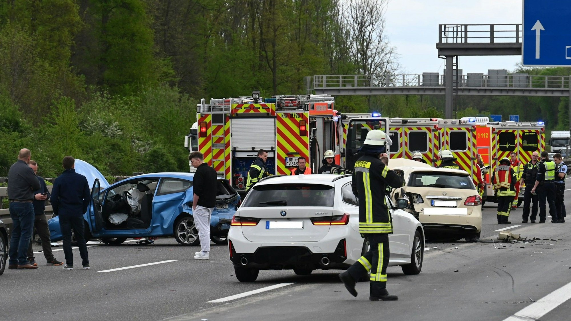 Das Bild zeigt mehrere Einsatzkräfte und die verunfallten Fahrzeuge auf der Autobahn.