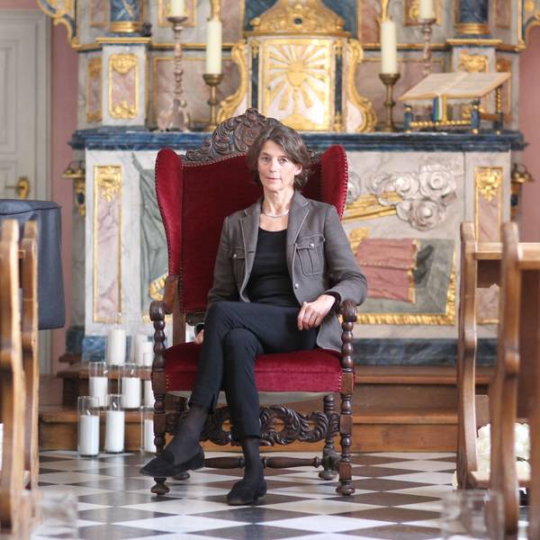 Eine Frau sitzt auf einem Stuhl in einem Kirchenraum