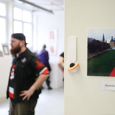Ein Besucher in der Ausstellung neben einem Foto, das den Bonner Hofgarten und die Universität zeigt.