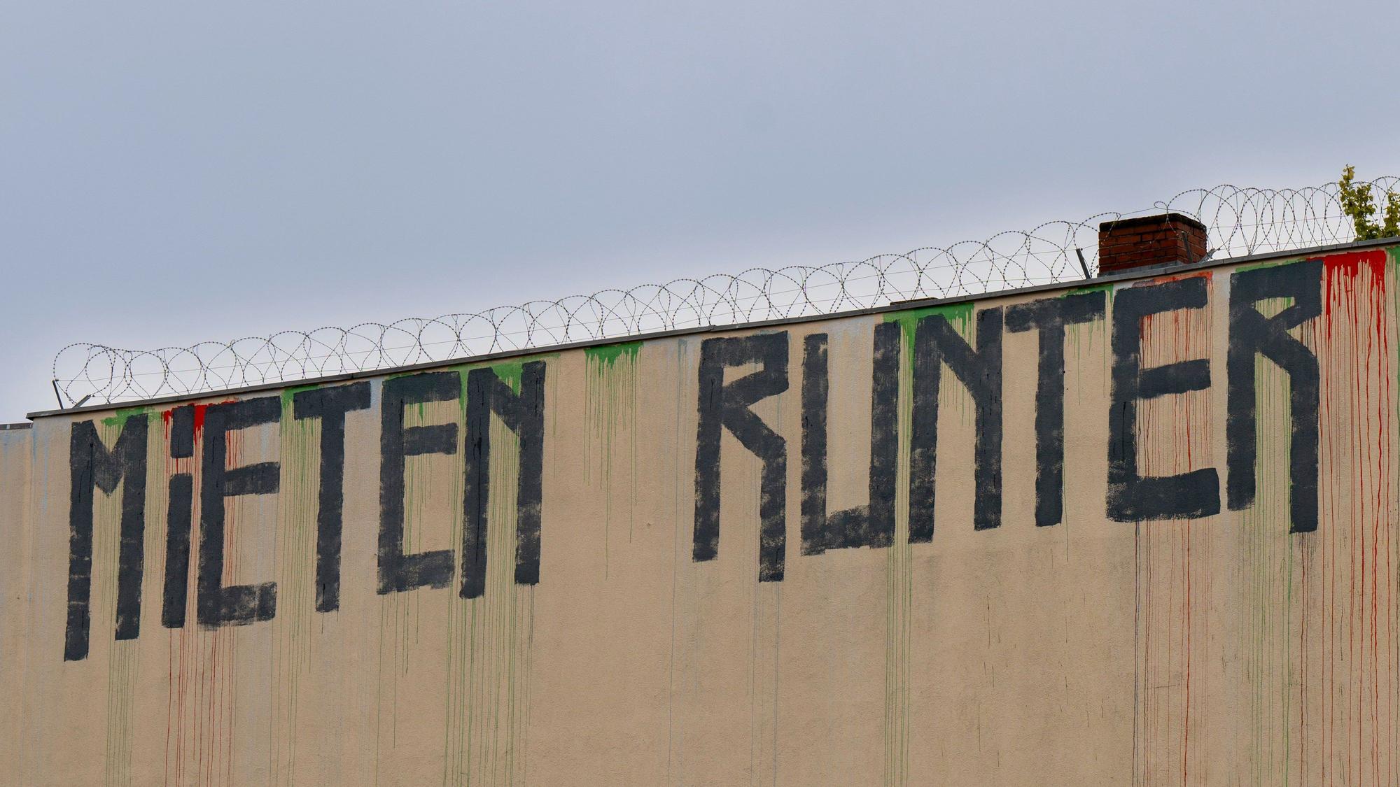 Berlin: Der Schriftzug „Mieten runter“ ist an der Wand eines Miethauses mit Graffiti beschmiert.