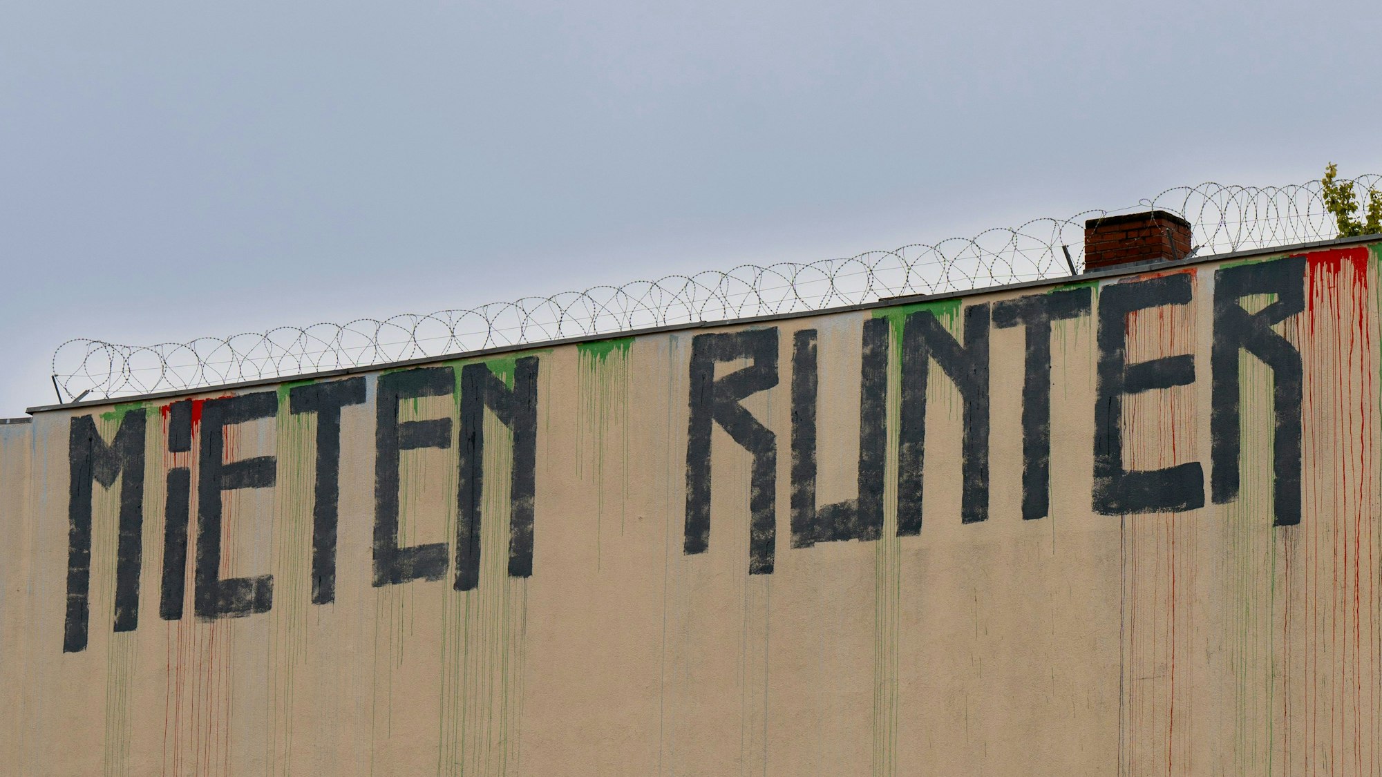 Berlin: Der Schriftzug „Mieten runter“ ist an der Wand eines Miethauses mit Graffiti beschmiert.