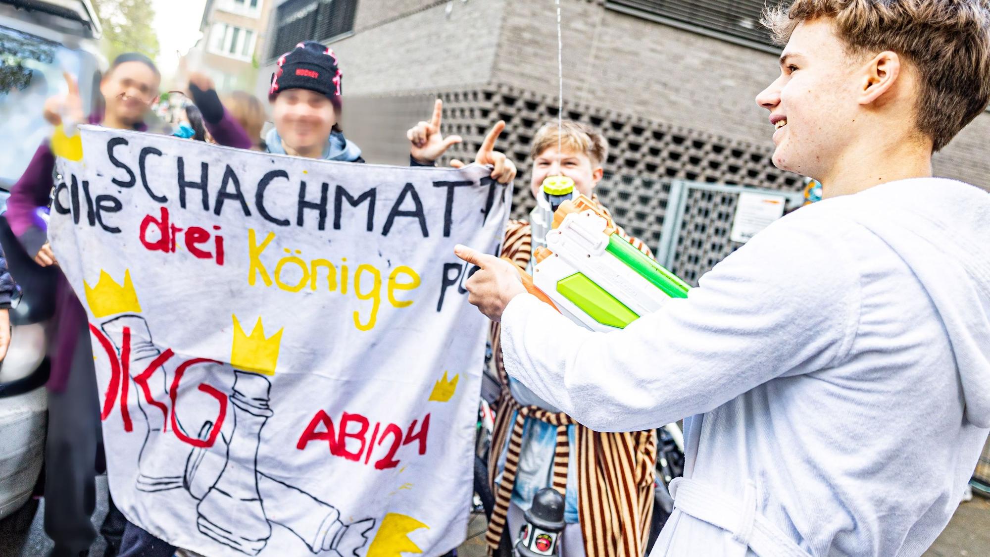 Schüler halten eine Flagge des Dreikönigsgymnasiums hoch.