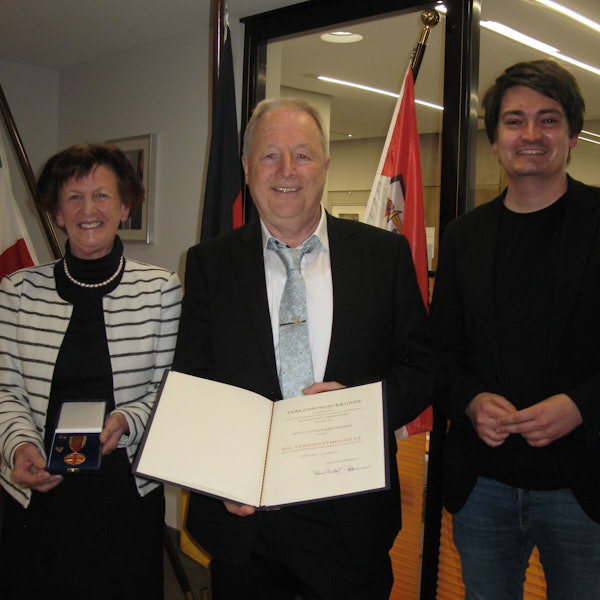 Der mit der Bundesverdienstmedaille ausgezeichnete Hennefer Heiner Krautscheid (71) steht zwischen Vizelandrätin Notburga Kunert und Bürgermeister Mario Dahm.