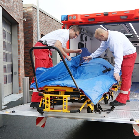 Mit einer Schwerlasttrage hantieren die Feuerwehrleute Oliver Schwarz (l) und Marc Elmhorst auf der Hebebühne des Schwerlastrettungswagens.