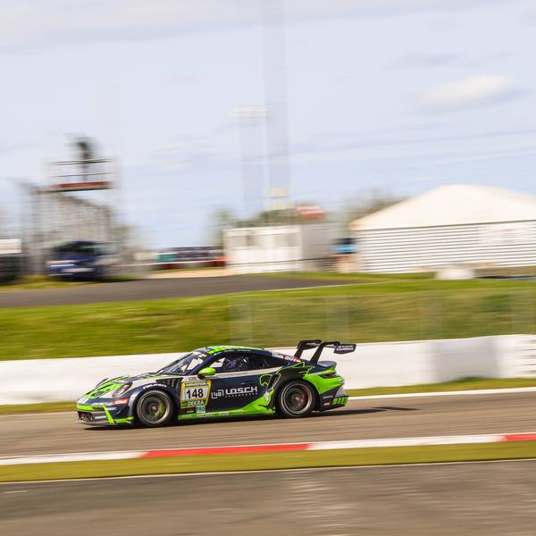 Der Porsche von Tobias Müller bewegt sich schnell auf dem Nürburgring. Der Hintergrund verschwimmt.