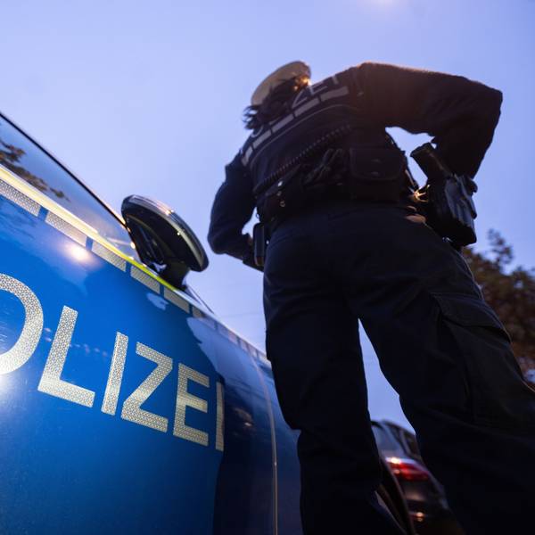 Eine Polizistin steht neben einem Polizeifahrzeug (Symbolbild).