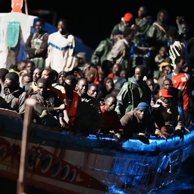 El Hierro: Migranten befinden sich dicht gedrängt in einem Holzboot, während sie zum Hafen in La Restinga auf der Kanareninsel El Hierro geschleppt werden.