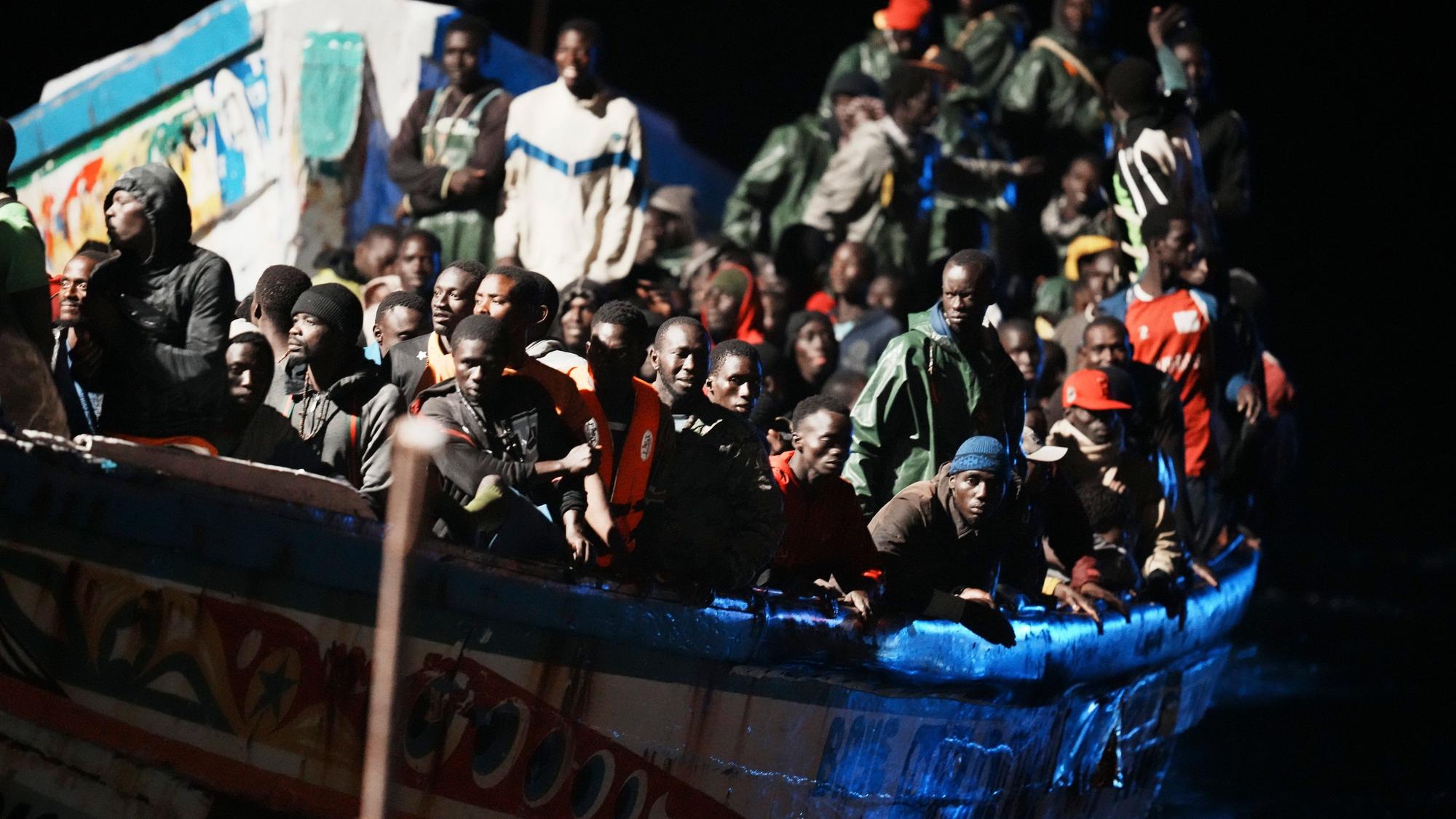 El Hierro: Migranten befinden sich dicht gedrängt in einem Holzboot, während sie zum Hafen in La Restinga auf der Kanareninsel El Hierro geschleppt werden.