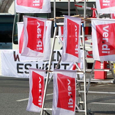 Am Betriebshof der Kölner Verkehrs-Betriebe (KVB) stehen angesichts eines Verdi-Warnstreiks im öffentlichen Nahverkehr mehrere leere Busse, im Vordergrund hängen Verdi-Fahnen.