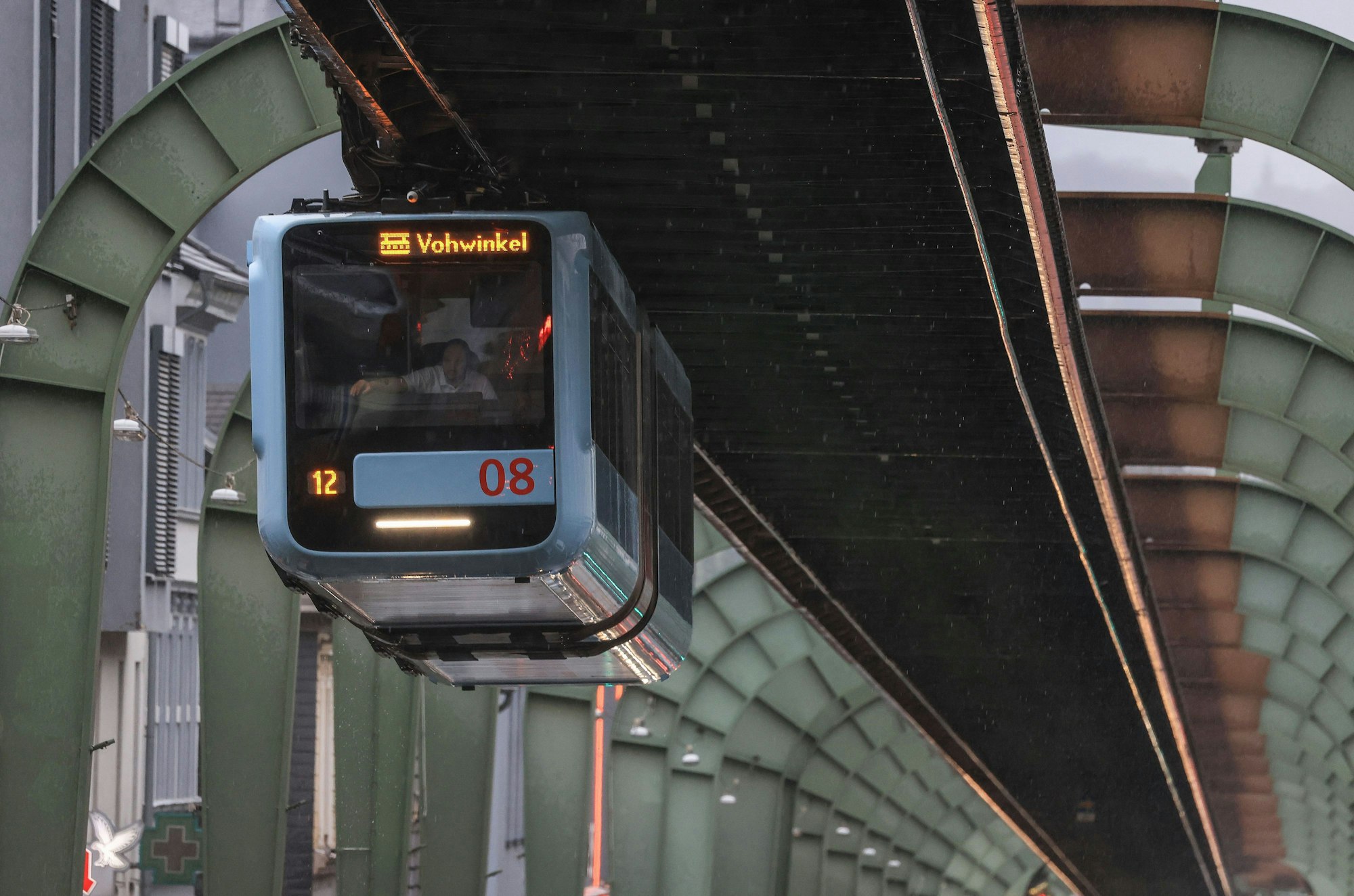 Eine Zug der Wuppertaler Schwebebahn fährt über einer Strasse im Stadtteil Vohwinkel.