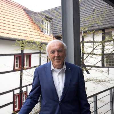 Das Bild zeigt Frank Günter Zehnder. Im Hintergrund sind Fachwerkhäuser zu sehen.