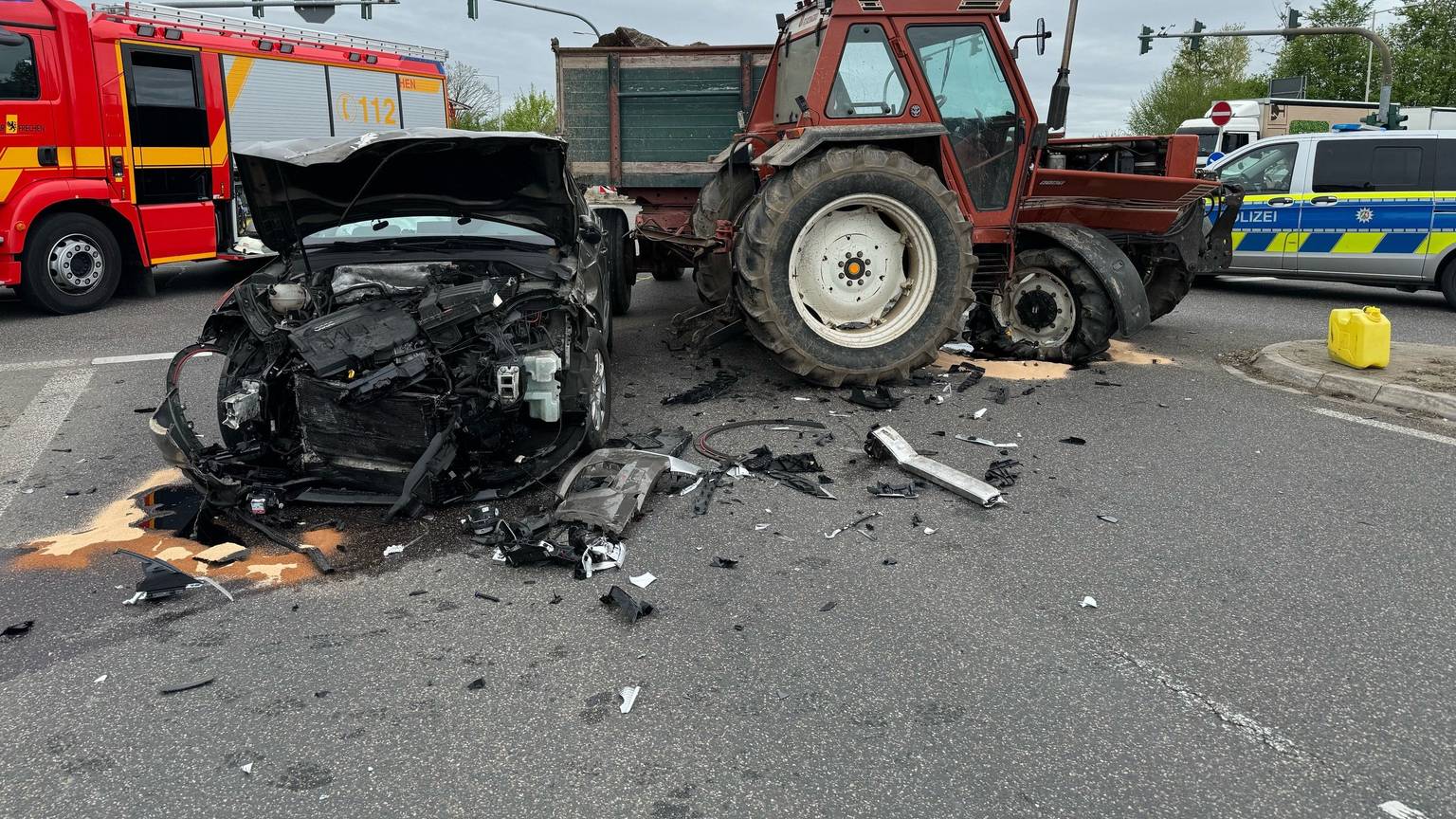 Das Bild zeigt einen beschädigten Pkw und einen beschädigten Traktor