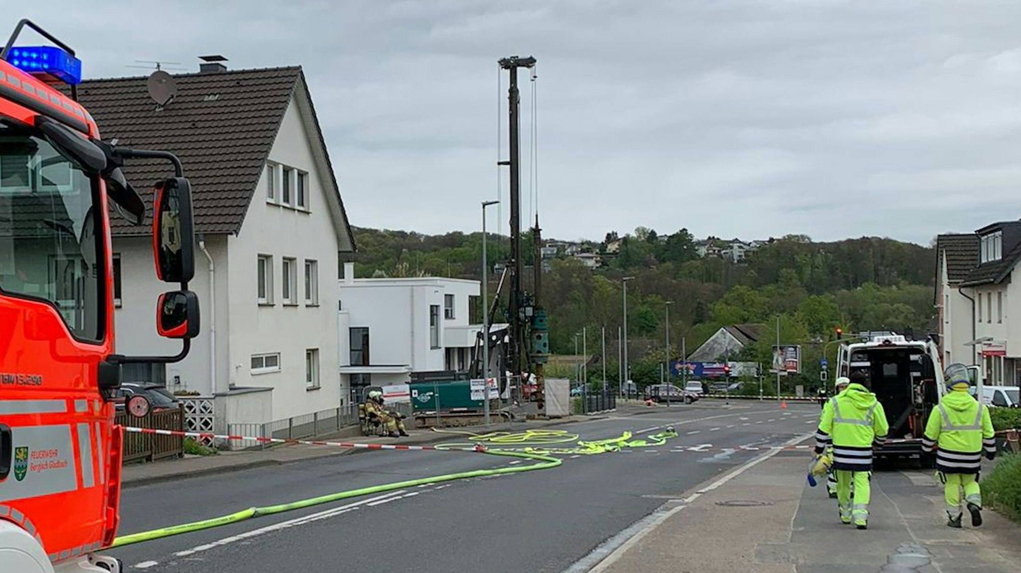 Auf der gesperrten Altenberger-Dom-Straße in Schildgen liegen Feuerwehrschläuche, im Vordergrund steht ein Feuerwehrfahrzeug.