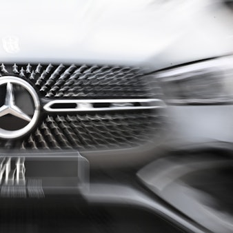Das Logo der Automarke Mercedes-Benz ist an der Front eines Fahrzeugs angebracht.