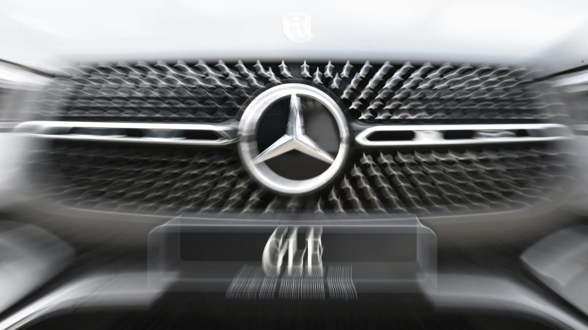Das Logo der Automarke Mercedes-Benz ist an der Front eines Fahrzeugs angebracht.