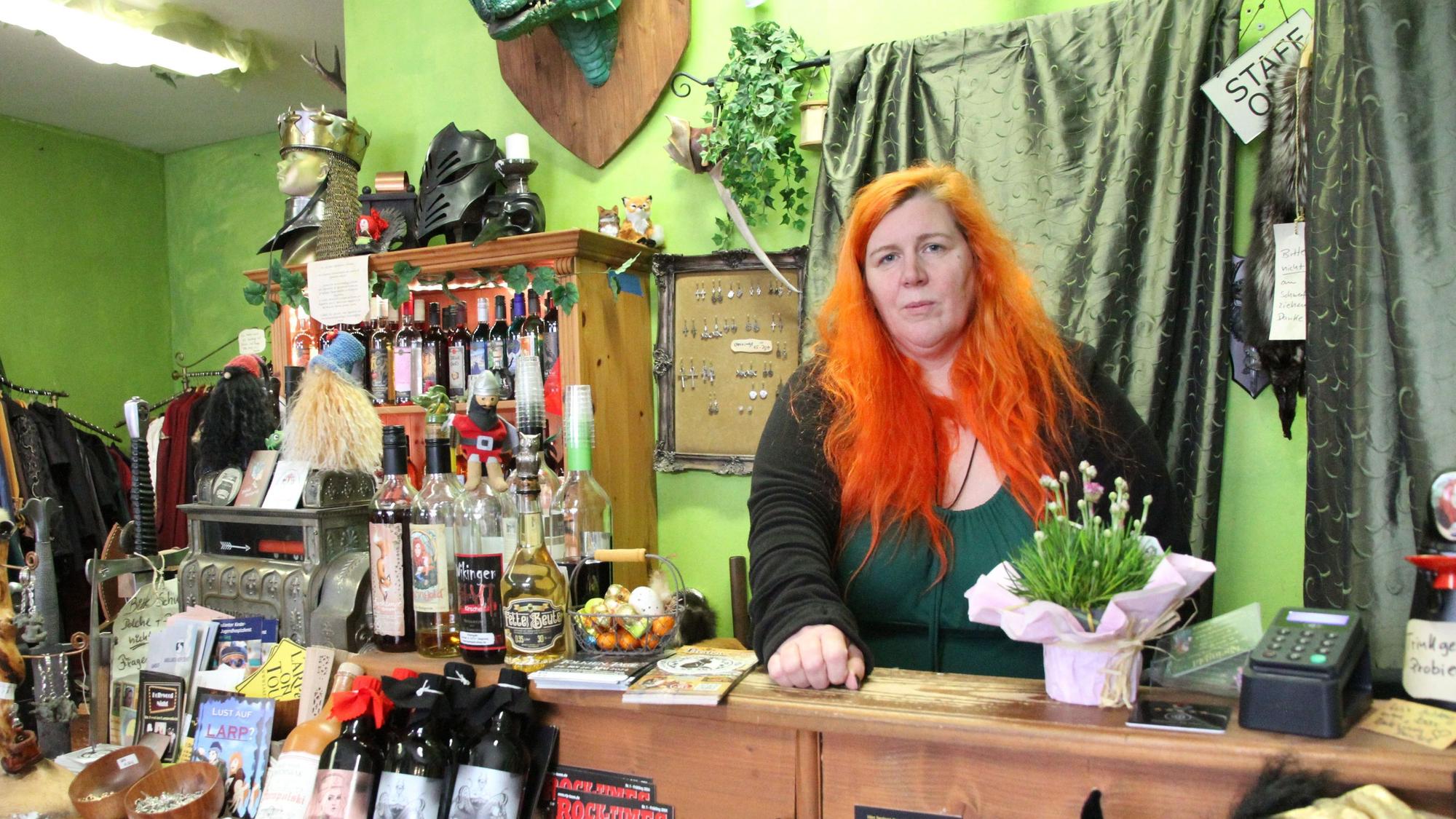 Eine Frau hinter der Verkaufstheke eines Mittelaltergeschäfts