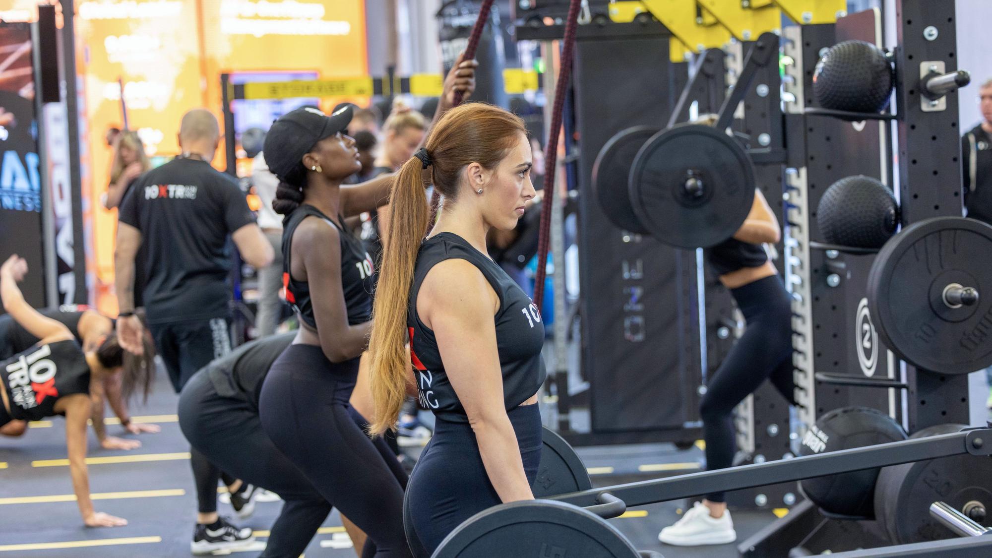 Menschen trainieren auf der Fitnessmesse Fibo an Kraftmaschinen