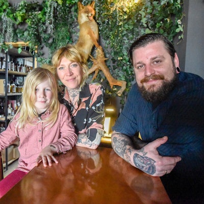 Auf dem Bild ist die Gastronomenfamilie in ihrer Bar zu sehen.