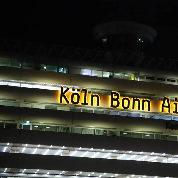 Das Logo Köln Bonn Airport leuchtet am Terminalgebäude des Flughafens.