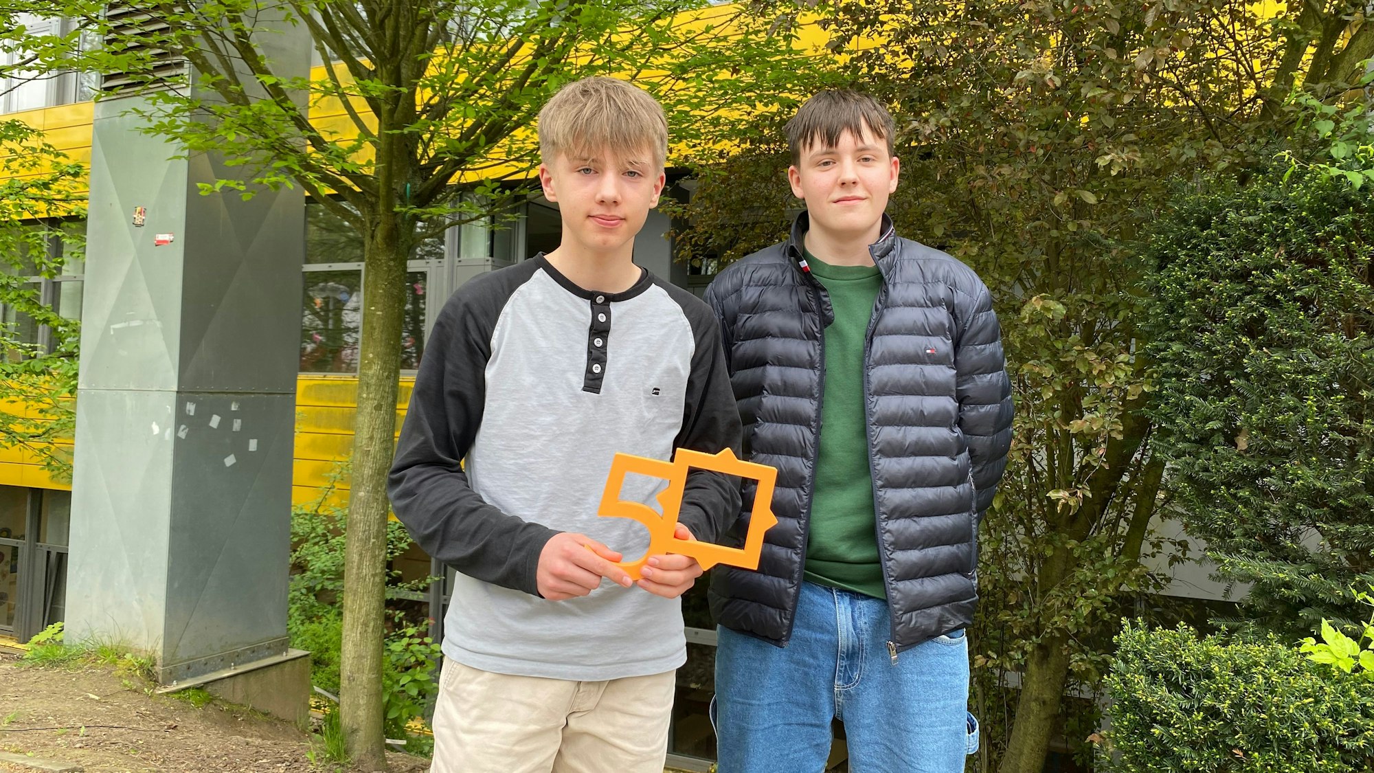 Zwei Jugendliche lächeln in die Kamera.