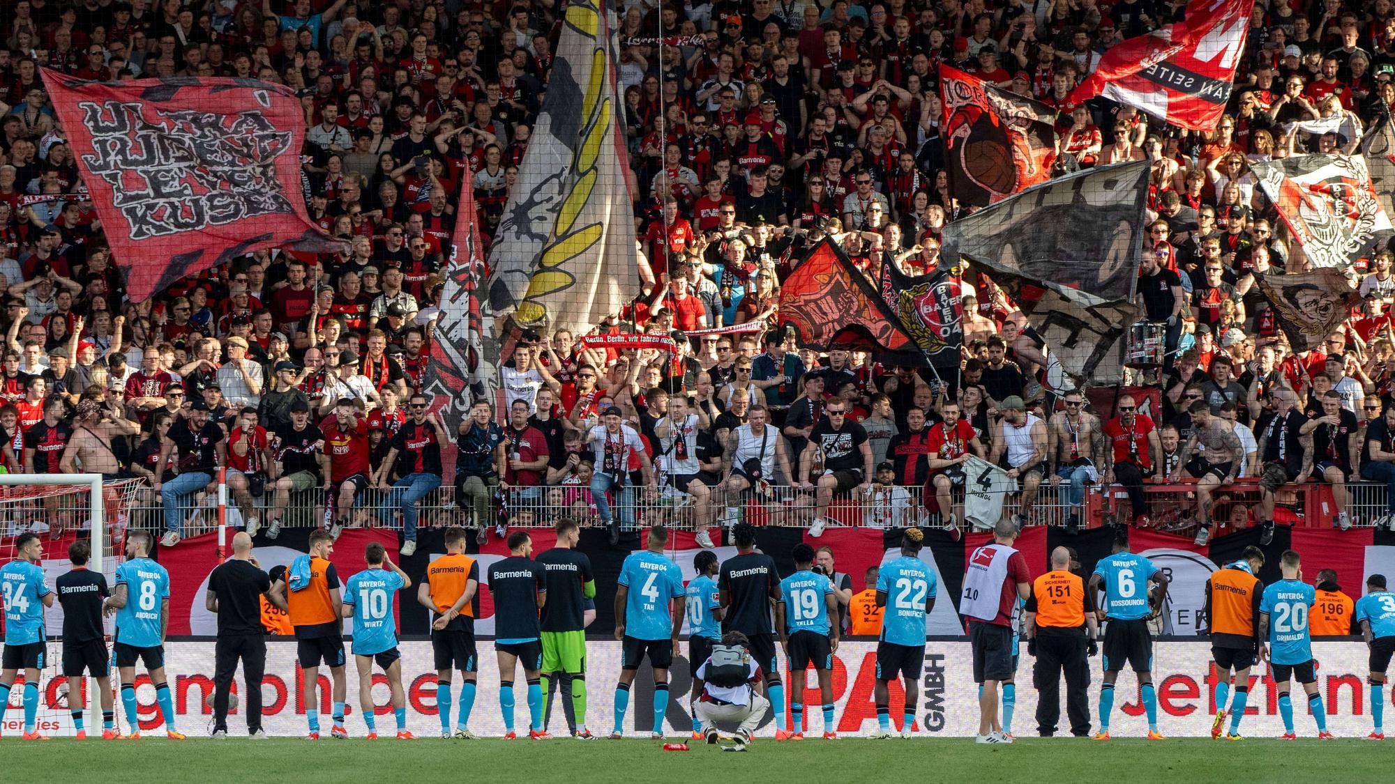Die Spieler von Bayer Leverkusen vor ihren jubelnden Fans.
