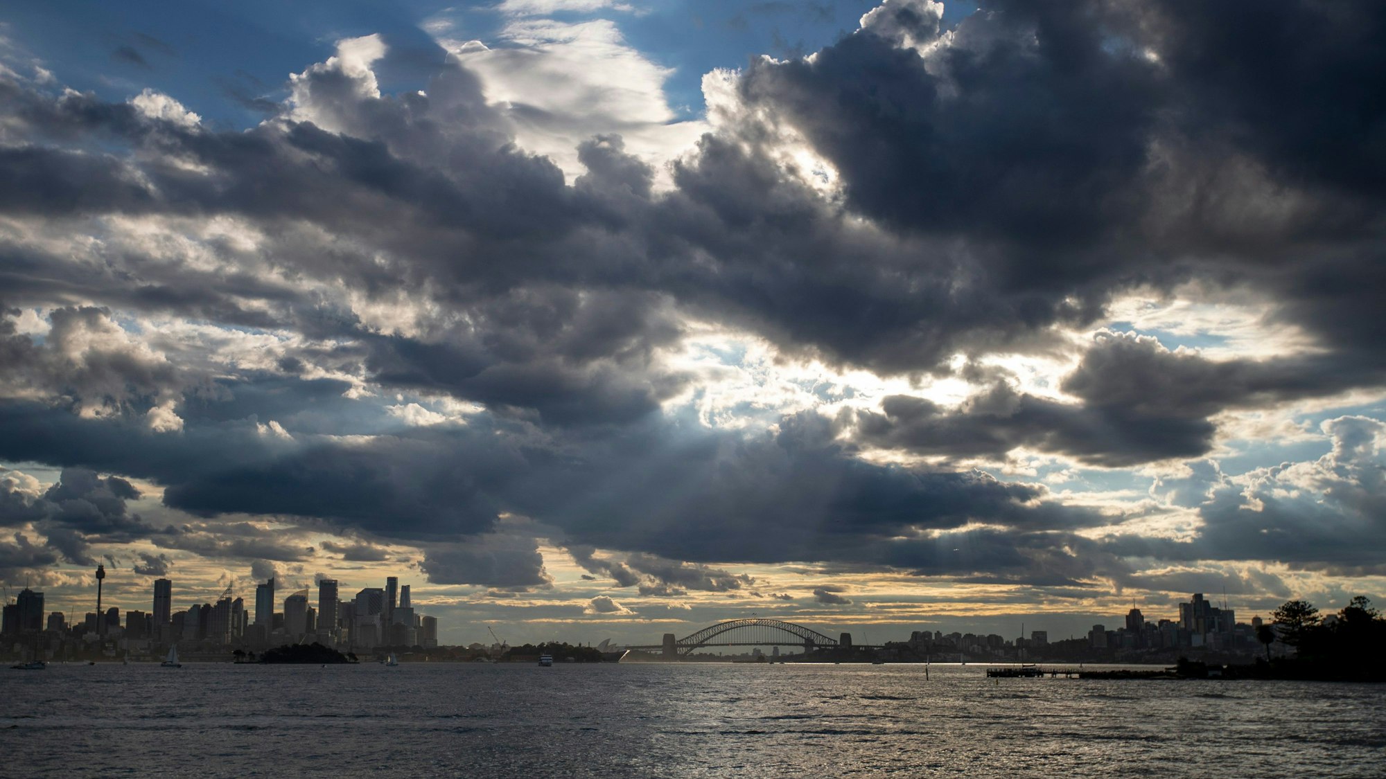 Wolken hängen über der Skyline von Sydney und der Harbor Bridge. (Symbolbild)